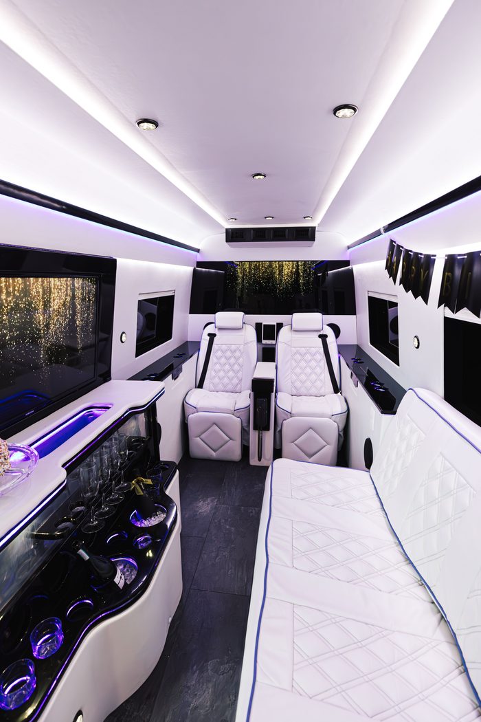Birthday celebration with champagne flutes and a Happy Birthday banner inside the Sprinter