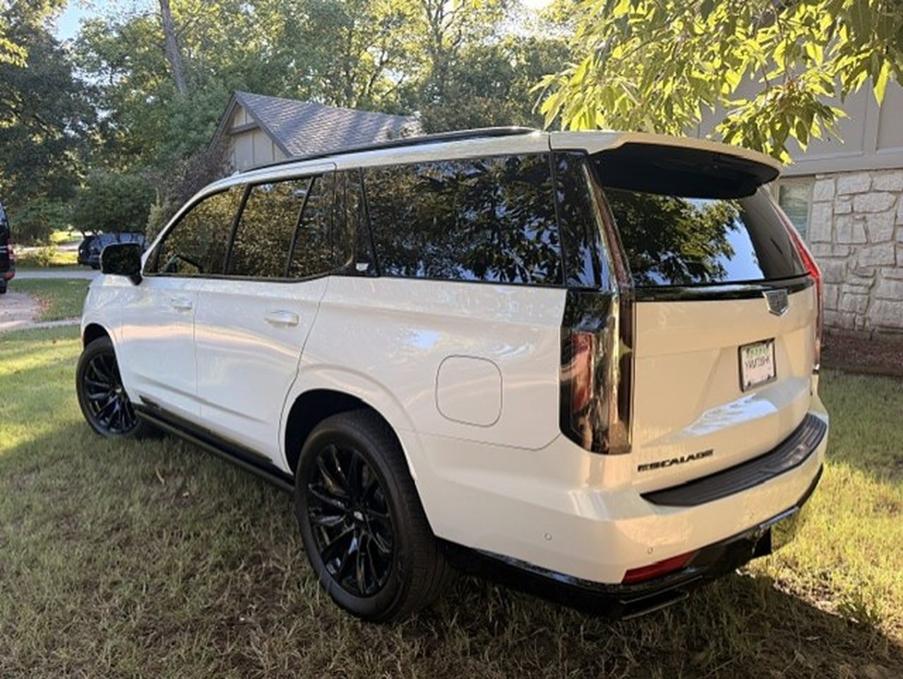 Rear three-quarter view of the white Cadillac Escalade