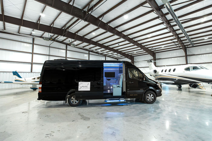 Black Mercedes Sprinter exterior in a private jet hangar